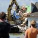 Chris and Katie Cramer watch on March 19, 2012, as their home is picked apart by a backhoe after it was destroyed by a tornado last March 15, 2012. The Cramer's and their young son Jack have moved to a nearby condo and will have to build a new home from the basement up. Melanie Maxwell I AnnArbor.com